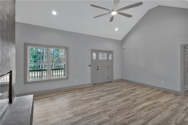 unfurnished living room featuring a high end fireplace, high vaulted ceiling, light hardwood / wood-style flooring, and ceiling fan