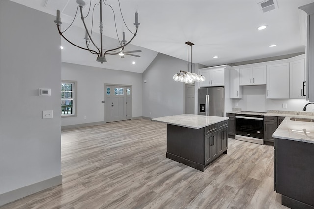 kitchen featuring sink, light hardwood / wood-style flooring, appliances with stainless steel finishes, a kitchen island, and white cabinetry