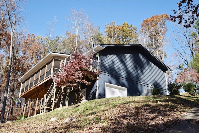 view of side of home featuring stairs and a deck