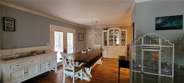 dining space featuring crown molding, dark wood-style floors, and french doors