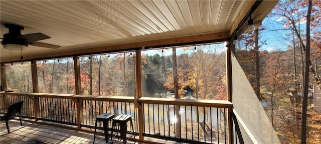 unfurnished sunroom with ceiling fan