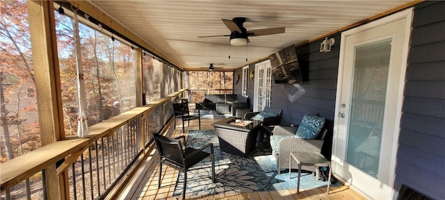 sunroom with an outdoor living space with a fire pit and ceiling fan