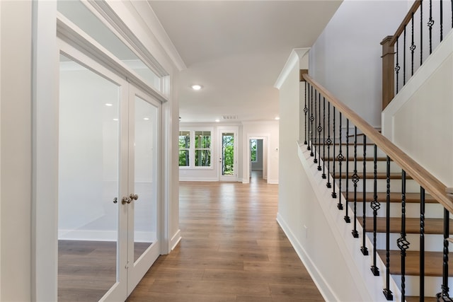 interior space featuring wood-type flooring and crown molding