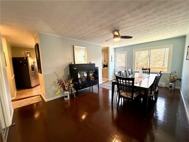 dining space with ceiling fan, baseboard heating, dark hardwood / wood-style flooring, crown molding, and a textured ceiling