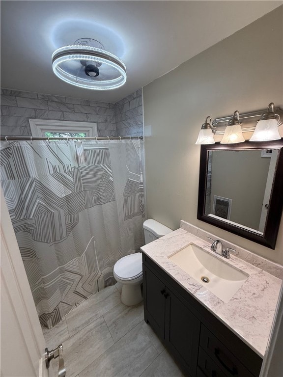 bathroom with a shower with shower curtain, vanity, and toilet