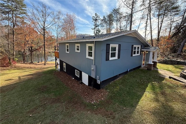 view of side of home featuring a yard and a water view