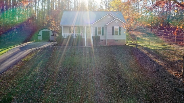 bungalow-style home with a storage unit and covered porch