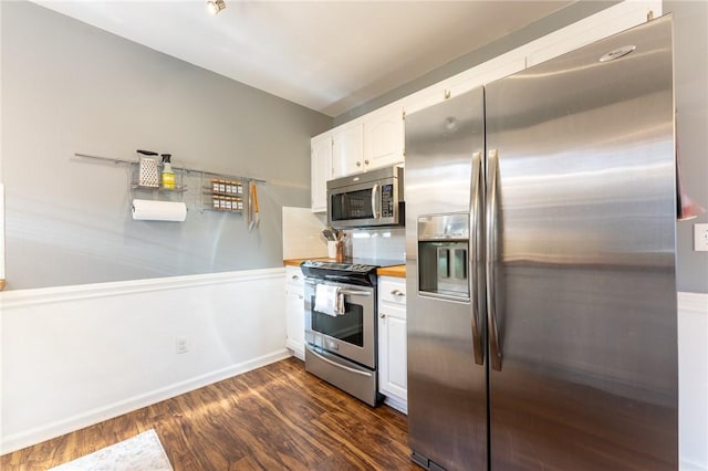 kitchen featuring dark wood-style flooring, baseboards, white cabinets, appliances with stainless steel finishes, and tasteful backsplash