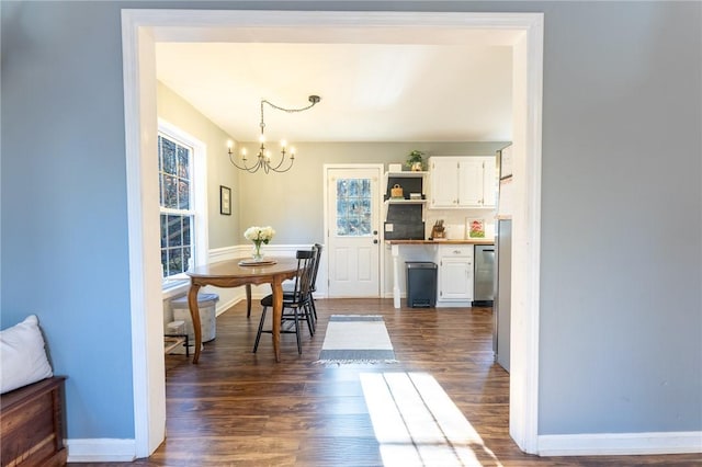 dining area with dark hardwood / wood-style floors and a chandelier