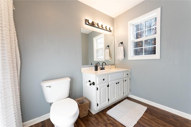 full bathroom with toilet, vanity, baseboards, and wood finished floors