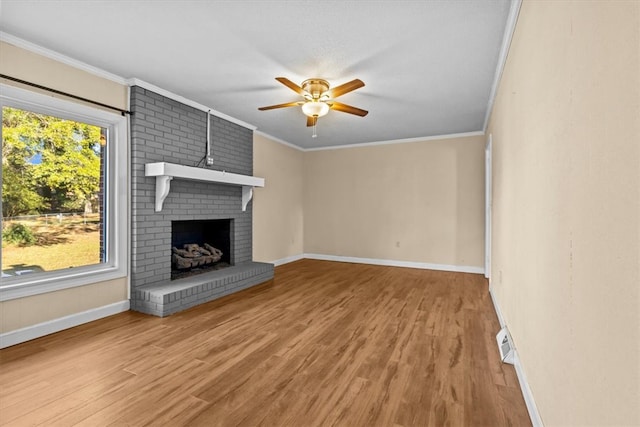 unfurnished living room featuring hardwood / wood-style flooring, plenty of natural light, ceiling fan, and a fireplace