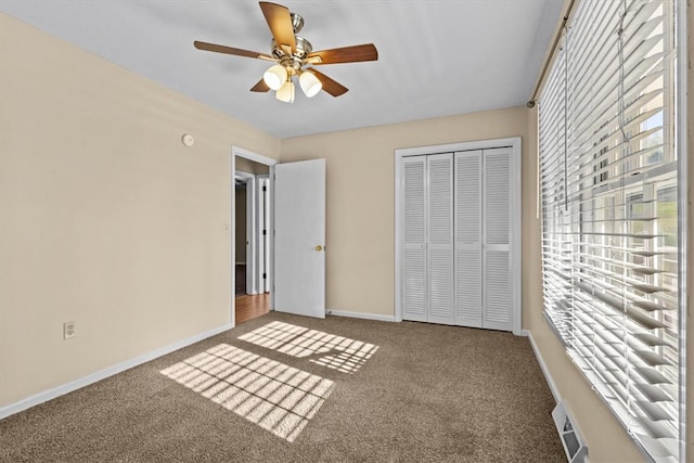 unfurnished bedroom with carpet, ceiling fan, and a closet