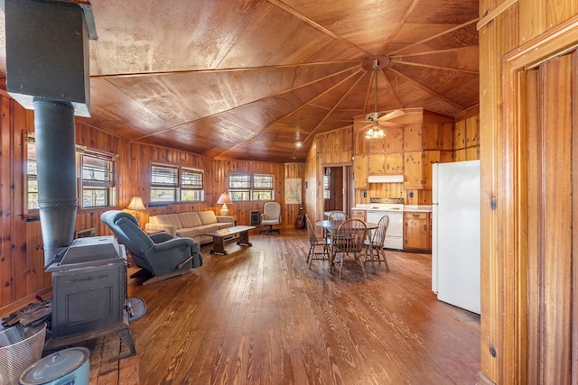 living room with hardwood / wood-style floors, a wood stove, wooden walls, and wood ceiling