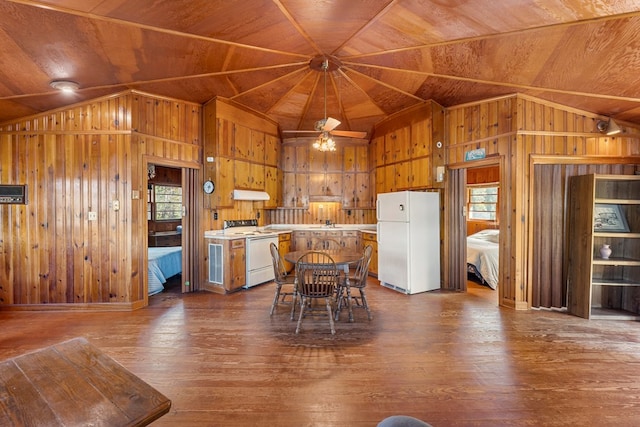 kitchen featuring white appliances, dark wood-type flooring, wooden walls, and wooden ceiling