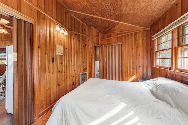 bedroom with wooden walls, wood ceiling, lofted ceiling, and white refrigerator