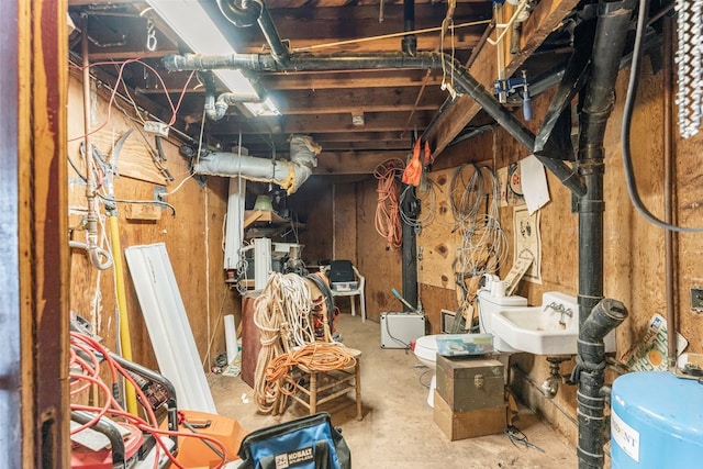 basement featuring sink and water heater