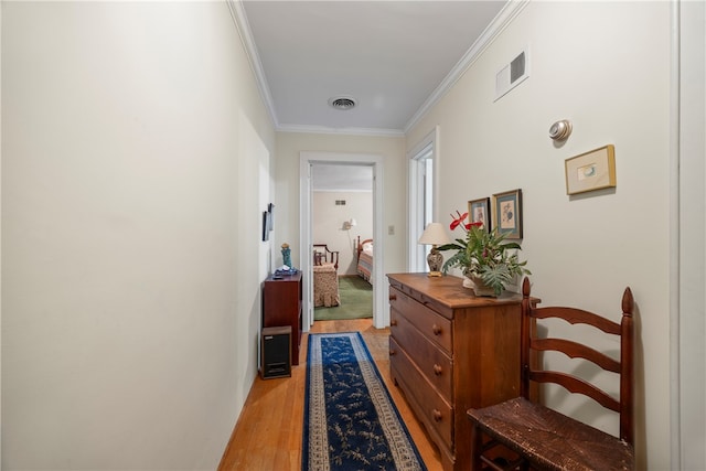 hall with crown molding and light hardwood / wood-style flooring