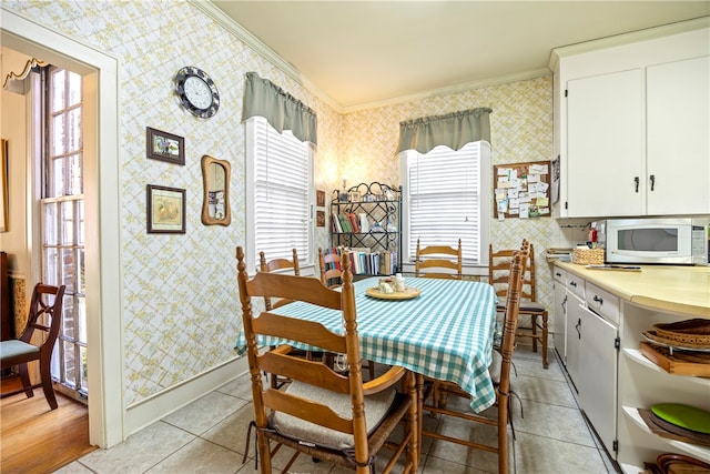 tiled dining space featuring crown molding