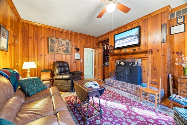 living room with a fireplace, ceiling fan, and ornamental molding