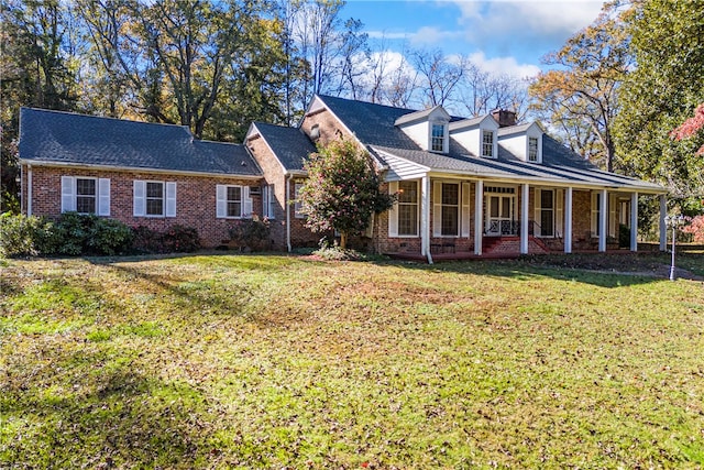 cape cod-style house featuring a front lawn and covered porch