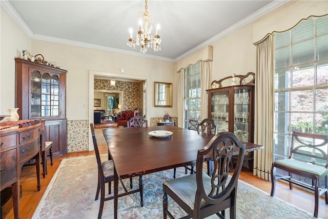 dining room with light hardwood / wood-style floors, crown molding, and a chandelier