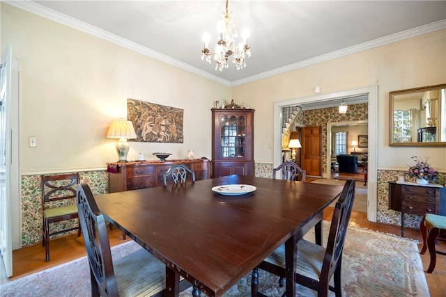 dining space featuring crown molding, hardwood / wood-style floors, and a chandelier