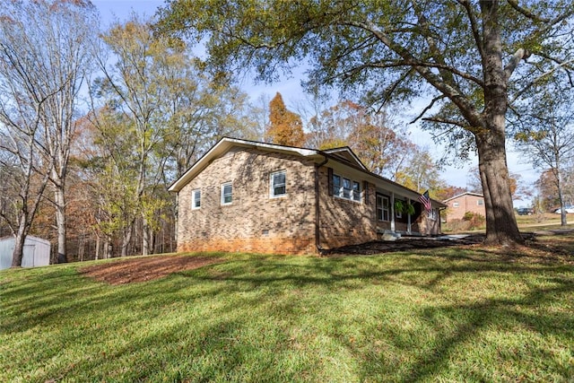 view of home's exterior with a lawn and a storage unit