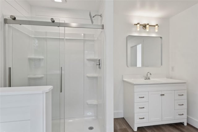 bathroom featuring wood-type flooring, vanity, and an enclosed shower