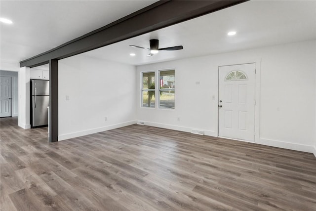 unfurnished living room featuring beamed ceiling, ceiling fan, and light hardwood / wood-style flooring