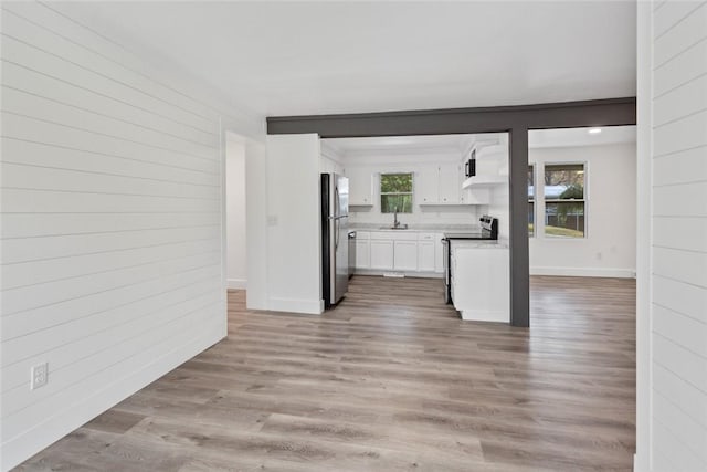 kitchen with sink, white cabinets, stainless steel appliances, and light wood-type flooring