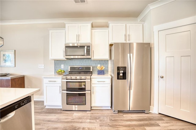 kitchen with tasteful backsplash, stainless steel appliances, light wood-type flooring, and white cabinets