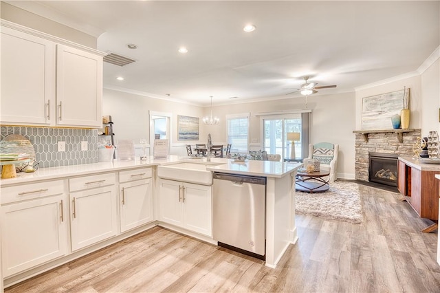 kitchen with sink, crown molding, white cabinets, stainless steel dishwasher, and kitchen peninsula