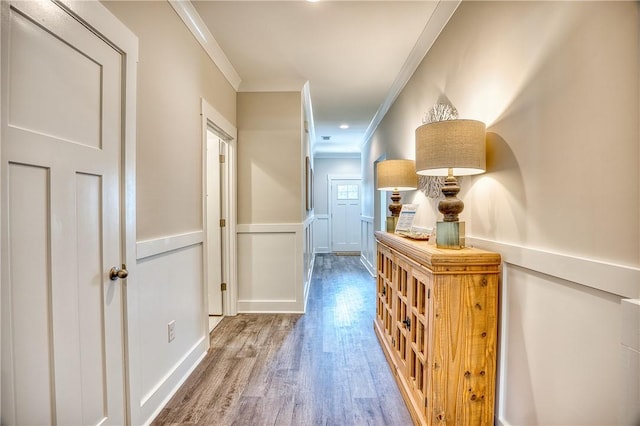 corridor with ornamental molding and hardwood / wood-style floors