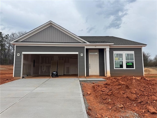 ranch-style house featuring driveway, a shingled roof, and an attached garage