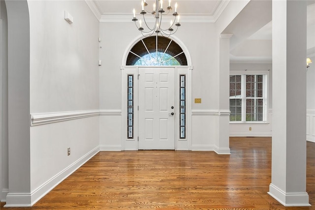 entryway featuring a chandelier, crown molding, and wood-type flooring