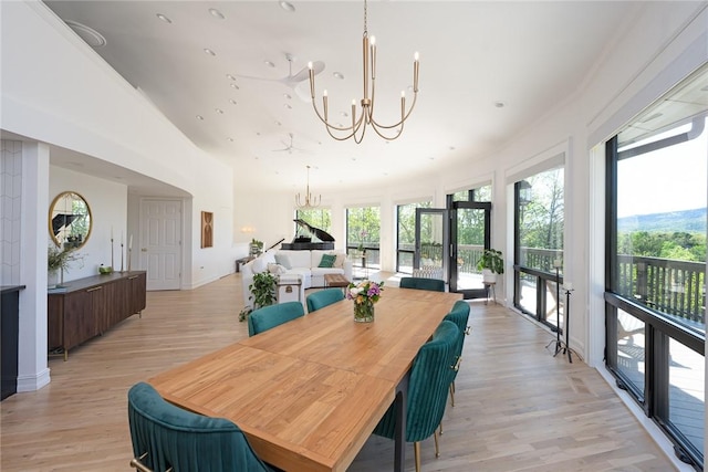 dining area with ceiling fan with notable chandelier and light hardwood / wood-style floors