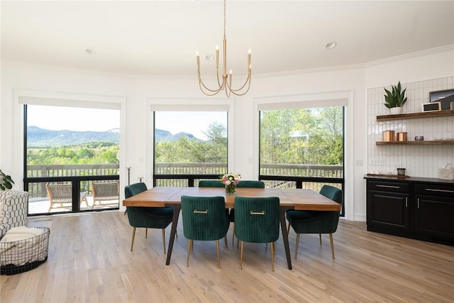 dining space with a mountain view, light wood-type flooring, and plenty of natural light