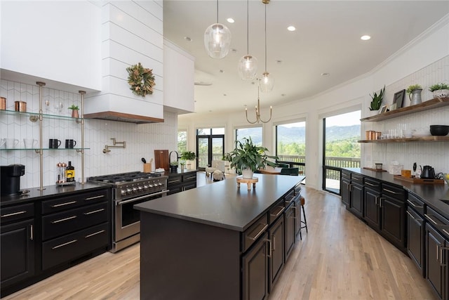 kitchen with plenty of natural light, a center island, high end range, and crown molding