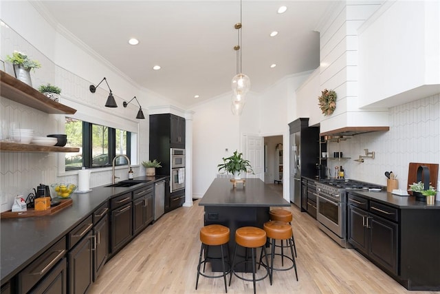 kitchen with a breakfast bar area, decorative backsplash, sink, and appliances with stainless steel finishes