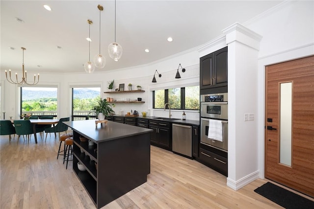 kitchen with sink, a kitchen island, a healthy amount of sunlight, and ornamental molding