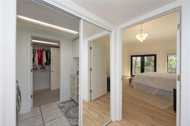 interior space with hardwood / wood-style floors, a notable chandelier, washer / dryer, and french doors