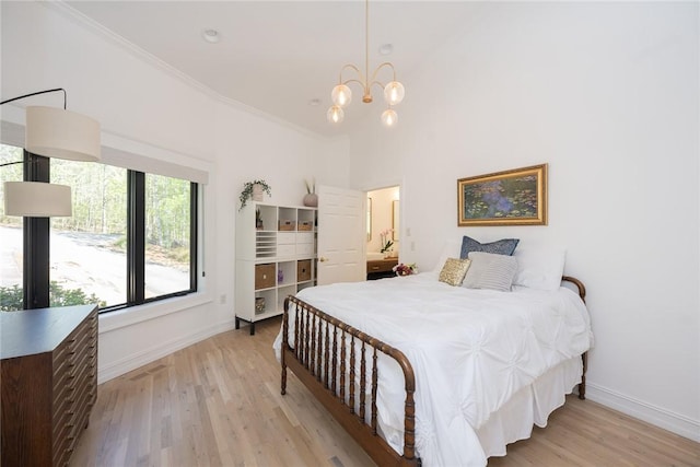 bedroom with a towering ceiling, light hardwood / wood-style flooring, ornamental molding, and a notable chandelier