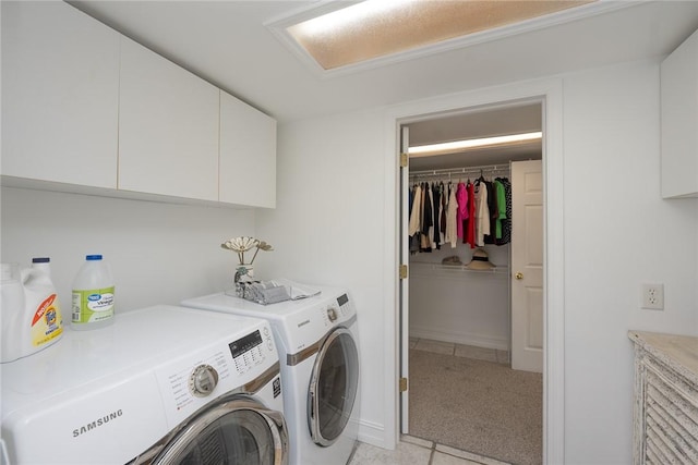 clothes washing area featuring cabinets, light tile patterned floors, and separate washer and dryer