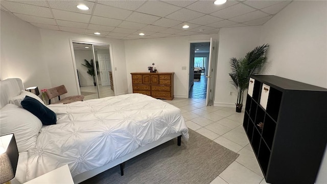 tiled bedroom with a closet and a drop ceiling