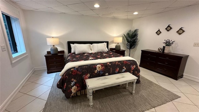 bedroom with a drop ceiling and light tile patterned floors