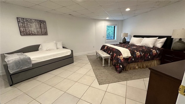 bedroom with a paneled ceiling and light tile patterned flooring