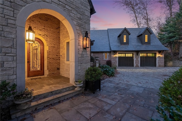 exterior entry at dusk with a garage