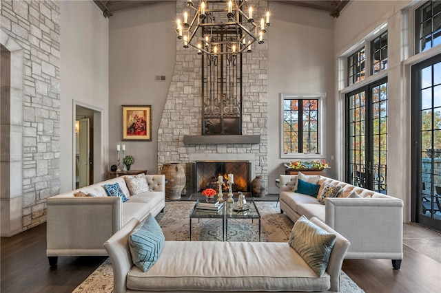 living room with high vaulted ceiling, french doors, hardwood / wood-style flooring, a fireplace, and a chandelier