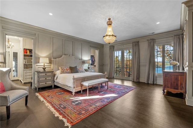 bedroom with a chandelier, french doors, and dark hardwood / wood-style floors