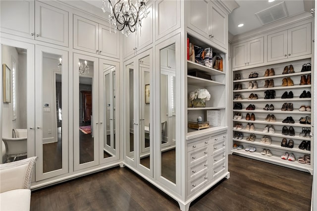 walk in closet featuring a notable chandelier and dark hardwood / wood-style flooring